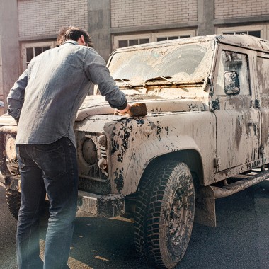 Un uomo pulisce un’auto sporca