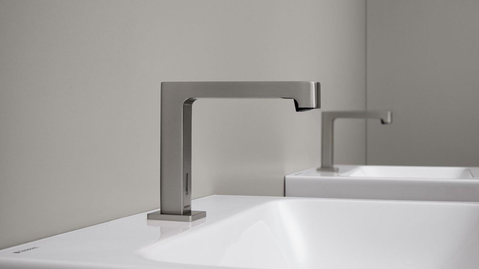 Rubinetto per lavabo senza contatto manuale: rubinetto monoforo Geberit Brenta dal design squadrato in acciaio inossidabile spazzolato Rubinetto per lavabo senza contatto manuale: rubinetto monoforo Geberit Brenta dal design squadrato in acciaio inossidabile spazzolato