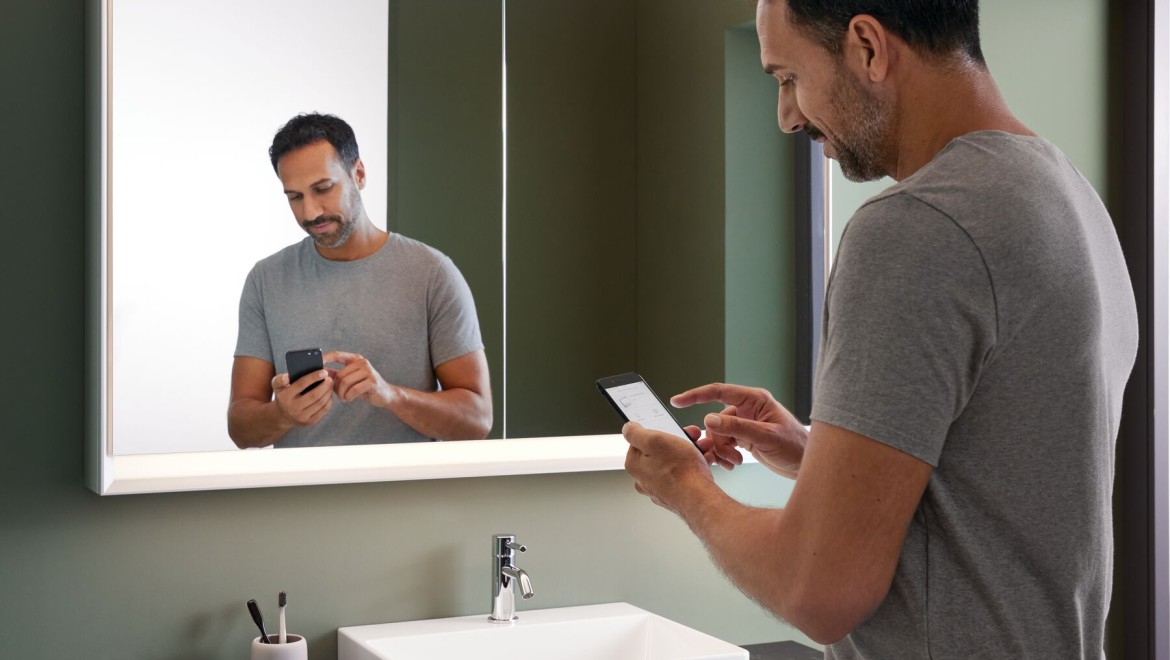 Uomo in bagno con un cellulare