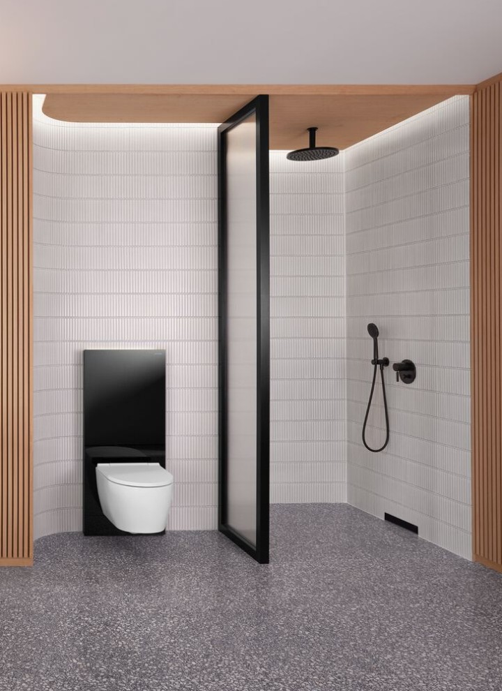 Ein Badezimmer mit Holzwand sowie einem Dusch- und WC-Bereich in Schwarz-Weiss