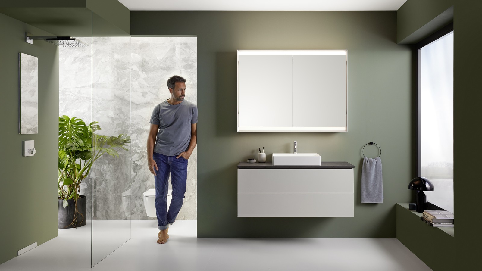 Mann steht in einem Badezimmer der Geberit ONE Badserie Mann steht in einem Badezimmer der Geberit ONE Badserie