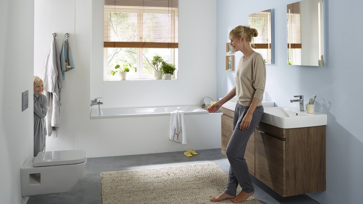 Femme et enfant dans une salle de bains familiale de la collection Geberit Renova (© Geberit)