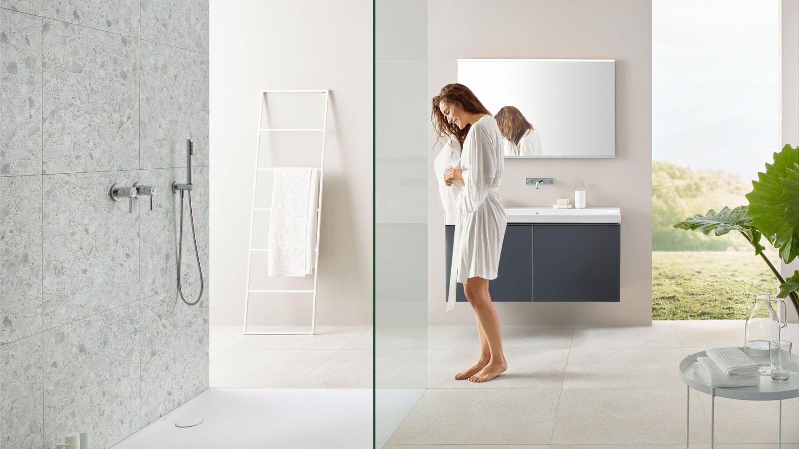 Frau steht in einem Badezimmer mit einer Walk-in-Dusche Frau steht in einem Badezimmer mit einer Walk-in-Dusche
