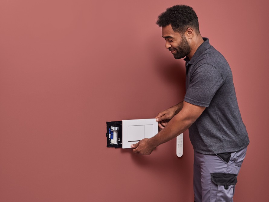 Homme installant le système d’absorption des odeurs Geberit DuoFresh