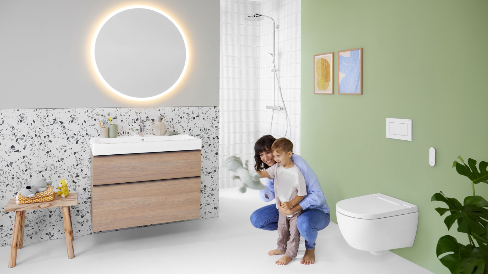 Geberit AquaClean Alba avec femme et enfant dans la salle de bains Geberit AquaClean Alba avec femme et enfant dans la salle de bains