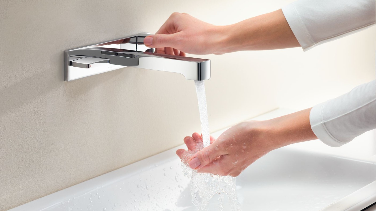 Macro immagine con le mani che girano un rubinetto Geberit ONE e controllano il flusso e la temperatura dell’acqua Macro immagine con le mani che girano un rubinetto Geberit ONE e controllano il flusso e la temperatura dell’acqua