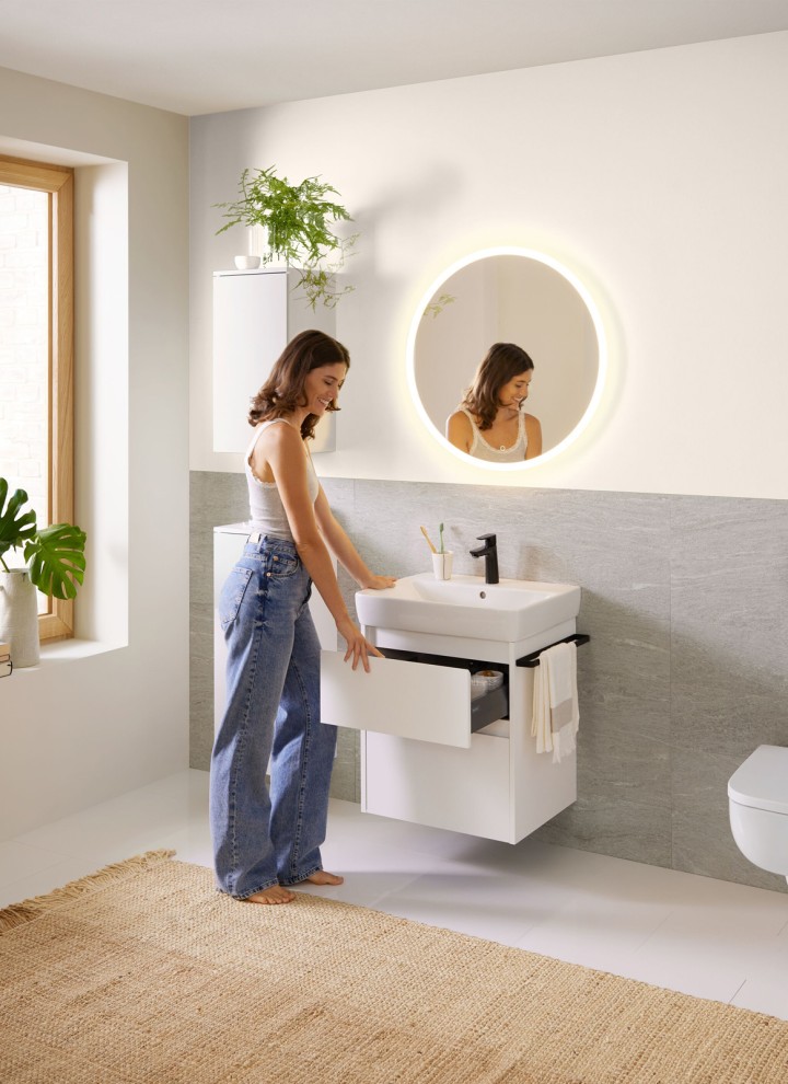 Donna in un bagno bianco della serie da bagno Geberit Renova Plan Donna in un bagno bianco della serie da bagno Geberit Renova Plan