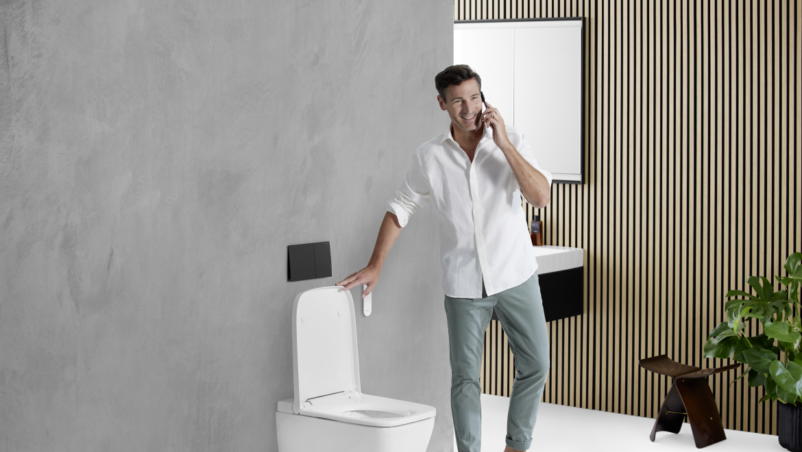 Mann in einem Badezimmer mit grauer Wand und AquaClean Sela Square
