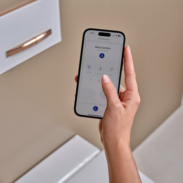 Eine Frau bedient die Geberit Home App auf einem Smartphone Eine Frau bedient die Geberit Home App auf einem Smartphone