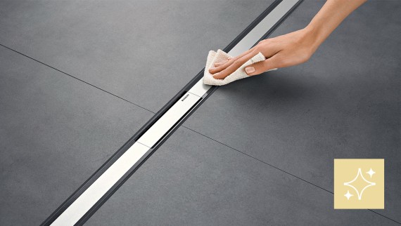 Une femme nettoie un écoulement de douche Geberit CleanLine Une femme nettoie un écoulement de douche Geberit CleanLine