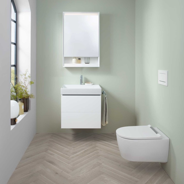Zona lavabo Geberit ONE con lavandino piccolo, mobile sottolavabo e armadietto a specchio nonché WCdoccetta. Zona lavabo Geberit ONE con lavandino piccolo, mobile sottolavabo e armadietto a specchio nonché WCdoccetta.
