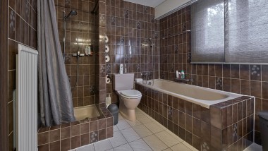 Bagno con angolo doccia stretto, vasca da bagno e WC a pavimento
