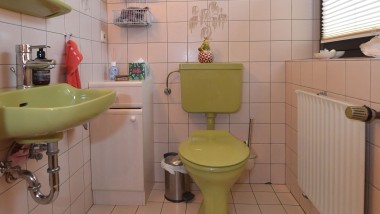 Il bagno degli ospiti verde degli anni '80 prima della ristrutturazione