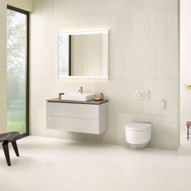 Une salle de bains en beige avec une armoire de toilette, un meuble sous lavabo, une plaque de déclenchement et des céramiques de Geberit
