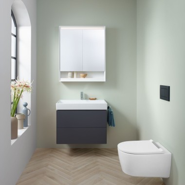 Un piccolo bagno color menta con un mobile sottolavabo color lava, un armadietto a specchio, una placca di comando e ceramiche Geberit