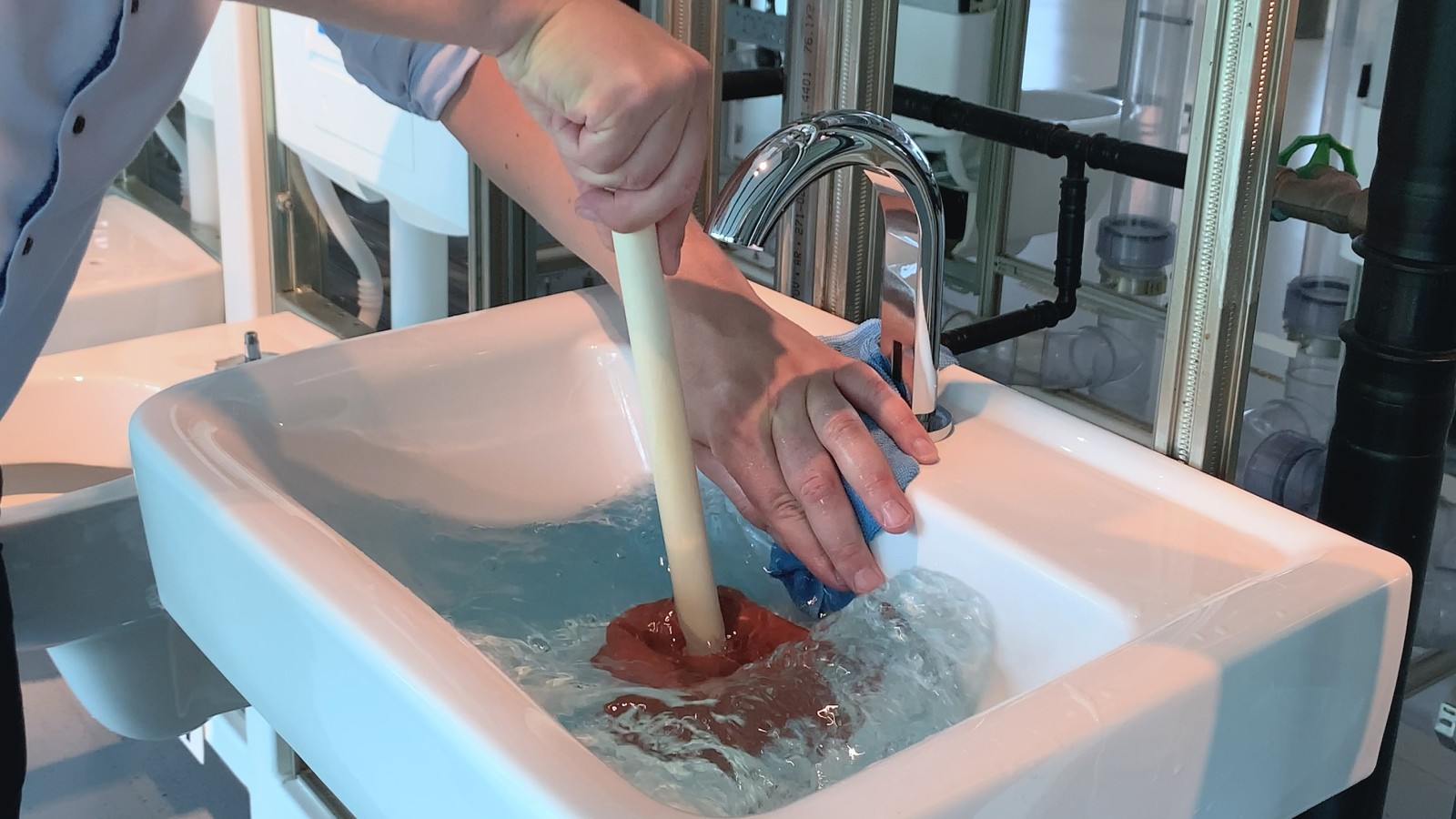 Coprire il foro di troppopieno con la mano e un panno Coprire il foro di troppopieno con la mano e un panno