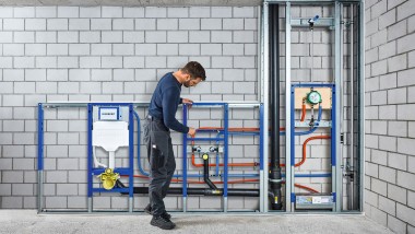 Installateur vor dem Geberit Duofix Installationssystem (© Geberit)