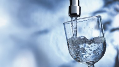 Glas wird gefüllt durch Hahnenwasser