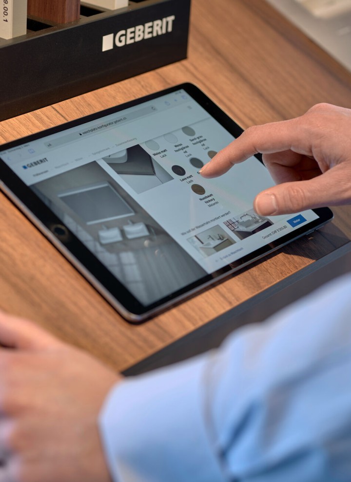 Un homme avec une tablette sélectionne des produits dans un configurateur