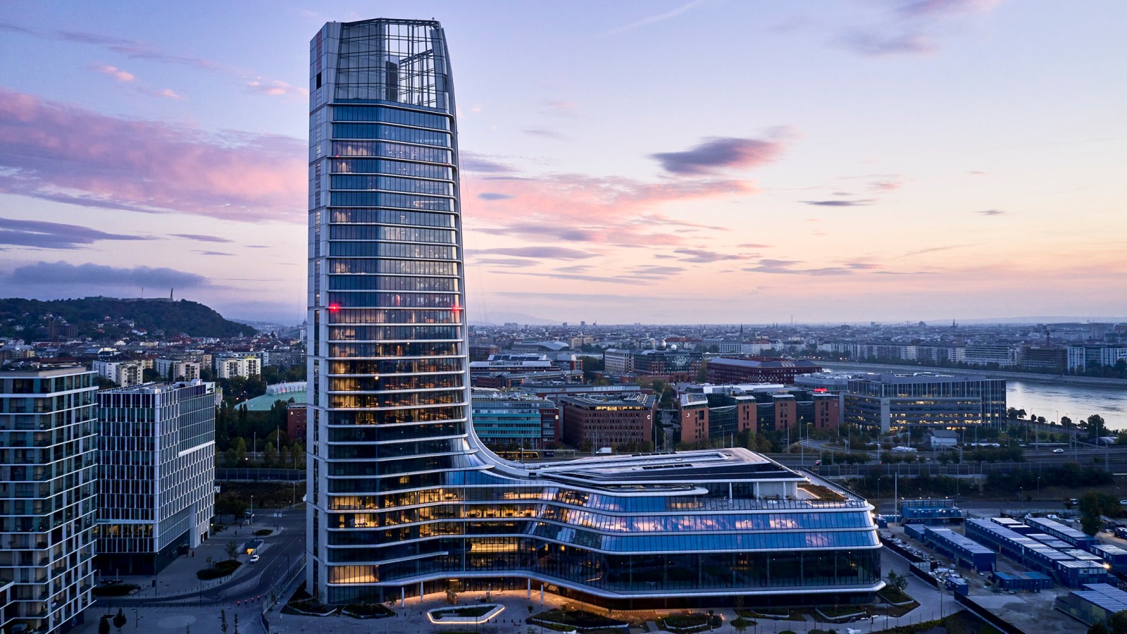 Visibile da lontano: Il Campus MOL, con la sua torre di 143 metri e il podio adiacente, è oggi l’edificio più alto dell’Ungheria (© MOL Gruppe) Visibile da lontano: Il Campus MOL, con la sua torre di 143 metri e il podio adiacente, è oggi l’edificio più alto dell’Ungheria (© MOL Gruppe)