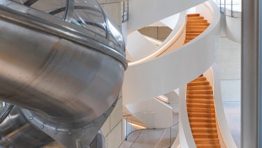 A lʼintérieur de la tour, un imposant escalier aux multiples courbes relie les étages. Les personnes qui le souhaitent peuvent utiliser un toboggan pour descendre. (© Adrian Deweerdt, Arles)