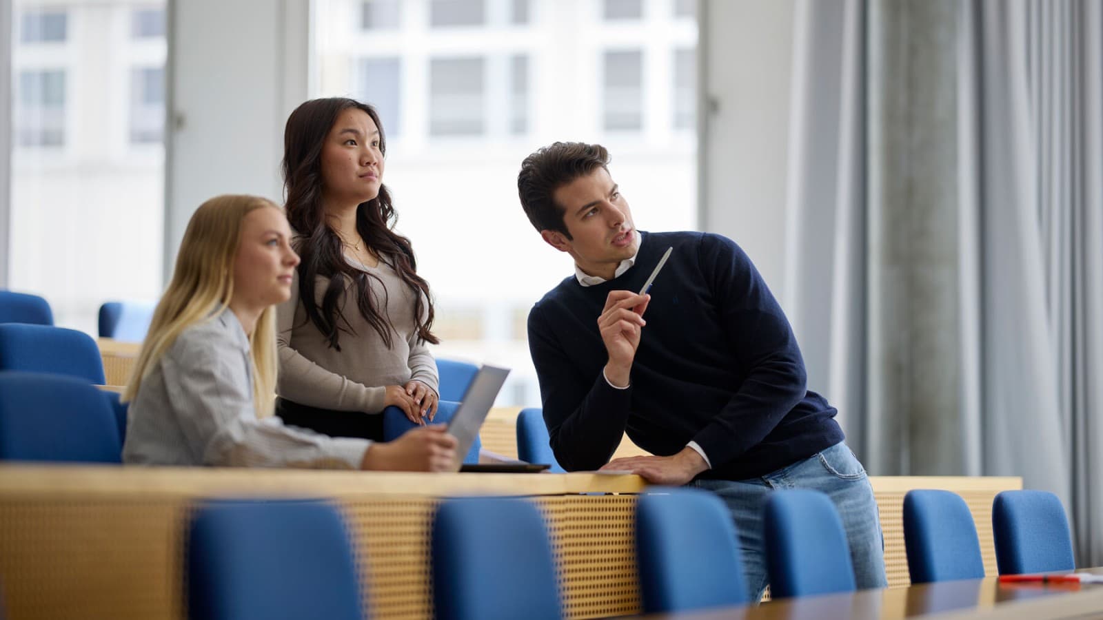 Drei Studierende betrachten eine Präsentation im Geberit Informationszentrum Drei Studierende betrachten eine Präsentation im Geberit Informationszentrum