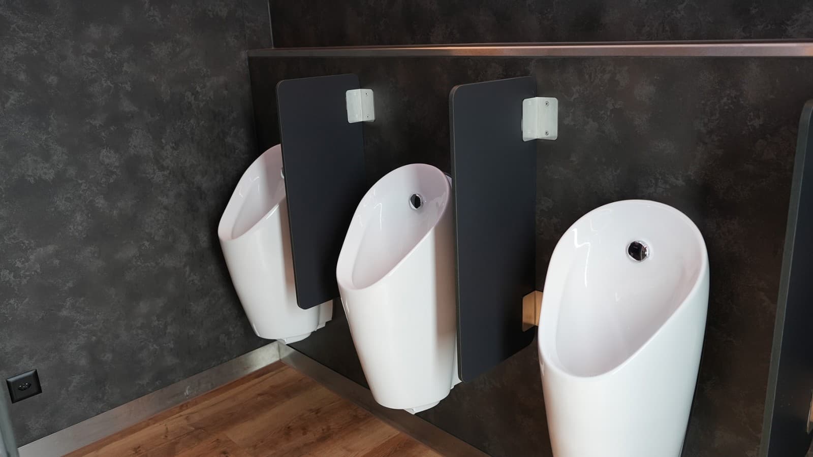 Moderne Geberit Preda Urinale mit integrierter Steuerung und Trennwänden in hochwertigem Sanitärbereich Moderne Geberit Preda Urinale mit integrierter Steuerung und Trennwänden in hochwertigem Sanitärbereich
