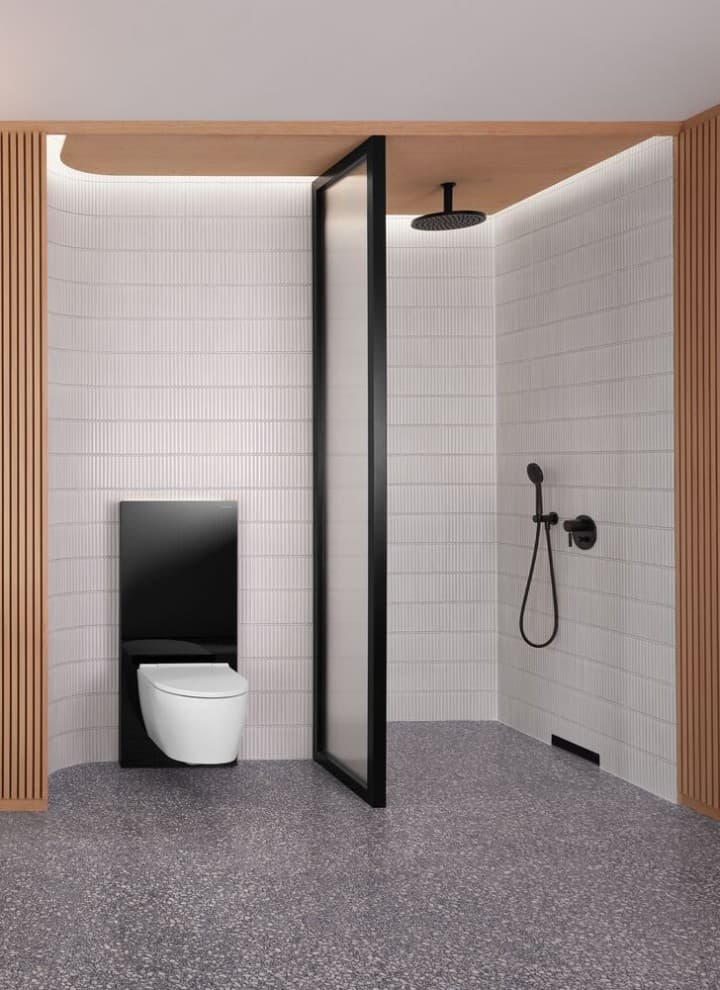 Ein Badezimmer mit Holzwand sowie einem Dusch- und WC-Bereich in Schwarz-Weiss Ein Badezimmer mit Holzwand sowie einem Dusch- und WC-Bereich in Schwarz-Weiss