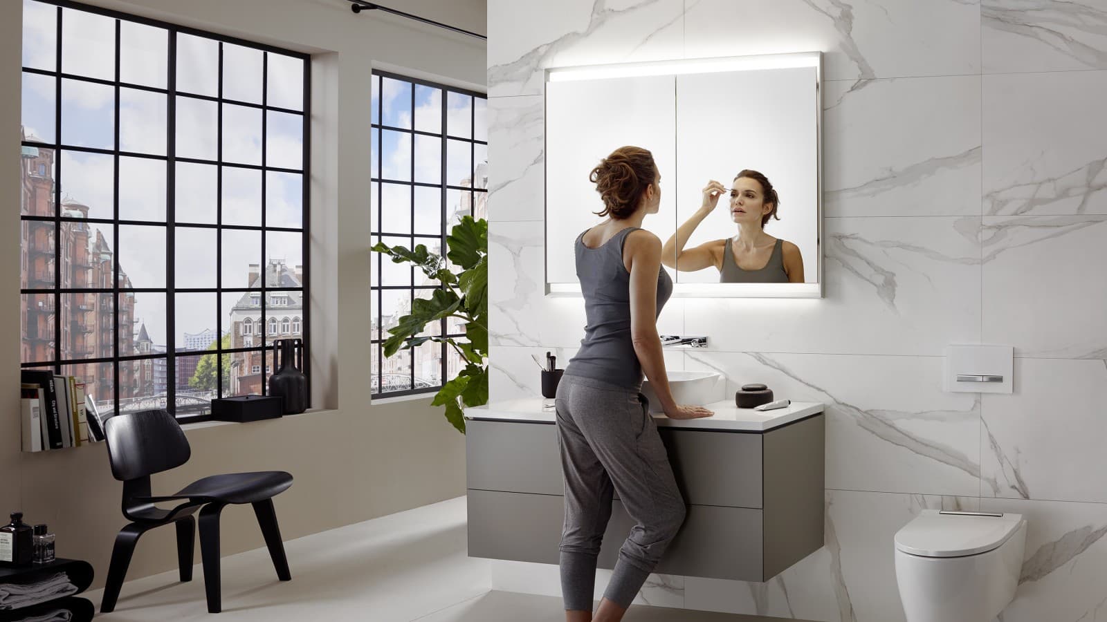 Una donna nel bagno Geberit ONE, in cui il lavabo è installato all'altezza ideale. Una donna nel bagno Geberit ONE, in cui il lavabo è installato all'altezza ideale.
