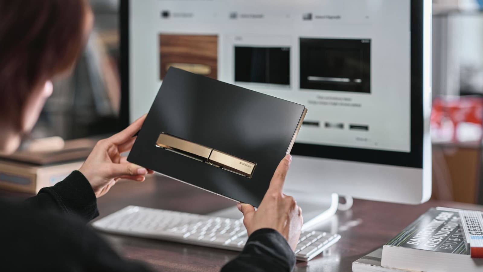 Femme avec plaque de déclenchement Geberit Sigma50, touches or rouge Femme avec plaque de déclenchement Geberit Sigma50, touches or rouge