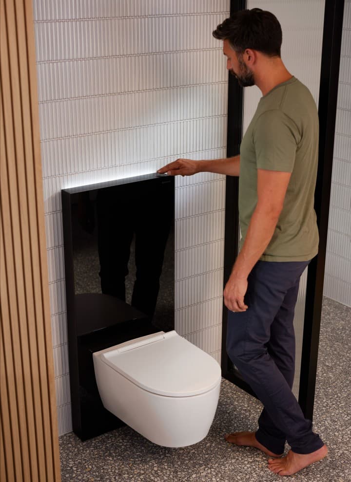 Mann neben Geberit Monolith Plus mit ComfortLight Mann neben Geberit Monolith Plus mit ComfortLight