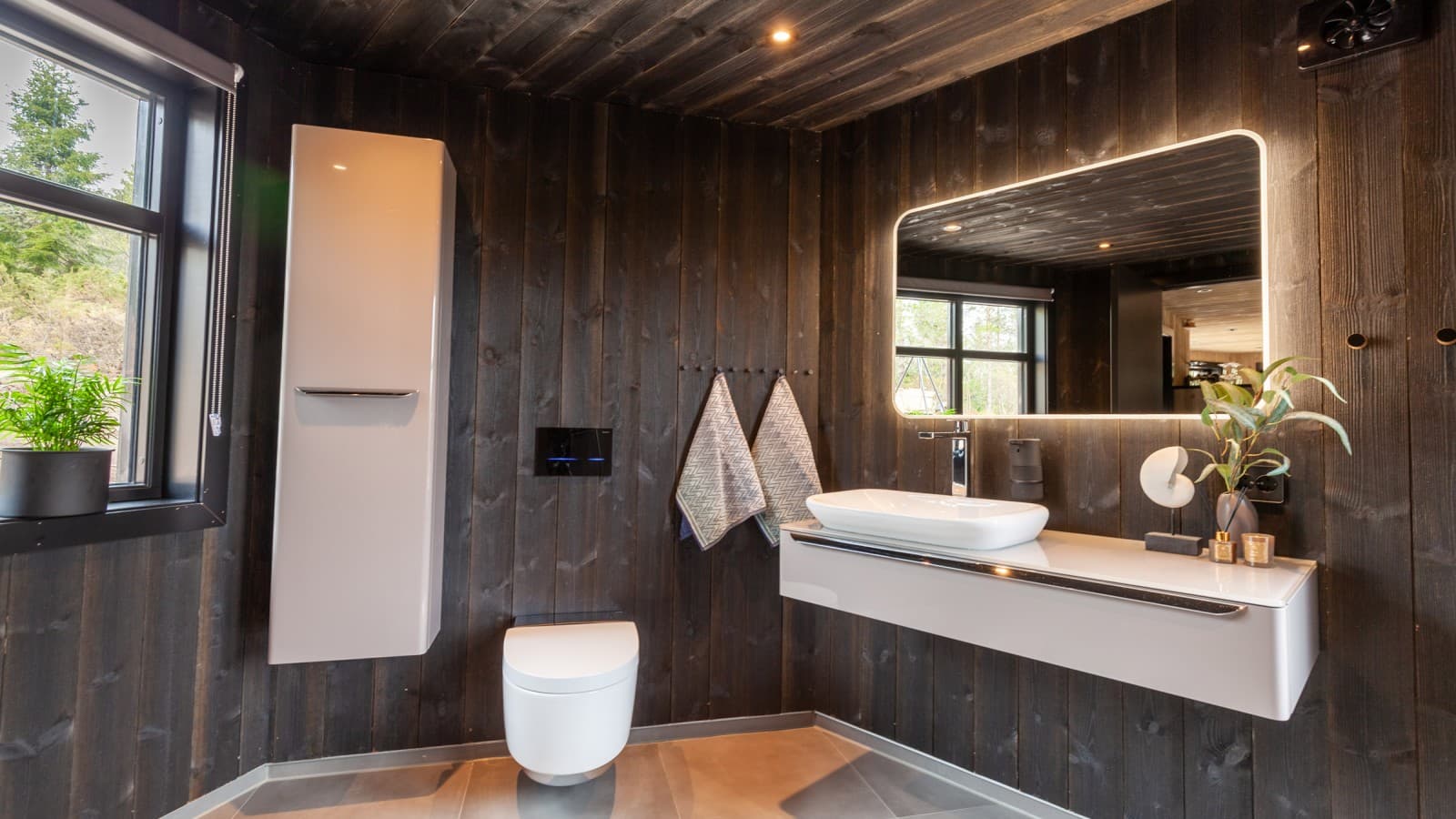Anche il bagno è rivestito in legno; oltre al WCdoccetta AquaClean Mera, qui si trovano anche altri prodotti Geberit davanti alla parete (© Geberit) Anche il bagno è rivestito in legno; oltre al WCdoccetta AquaClean Mera, qui si trovano anche altri prodotti Geberit davanti alla parete (© Geberit)